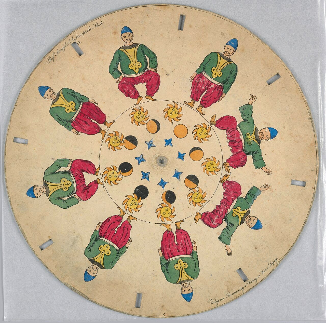Tarcza stroboskopowa Simona Stampfera, ok. 1835, Cooper Hewitt, Smithsonian Design Museum - papierowy krążek z ręcznie kolorowaną litografią: dziesięć figur tego samego tancerza w zielonej kurtce, czerwonych szarawarach i niebieskiej czapce ustawionych w krąg w kolejnych fazach ruchu, w środku wianuszek żółtych słoneczek z twarzami i niebieskich gwiazdek, a przy krawędzi wycięte wąskie szpary, przez które ogląda się wirujący krążek