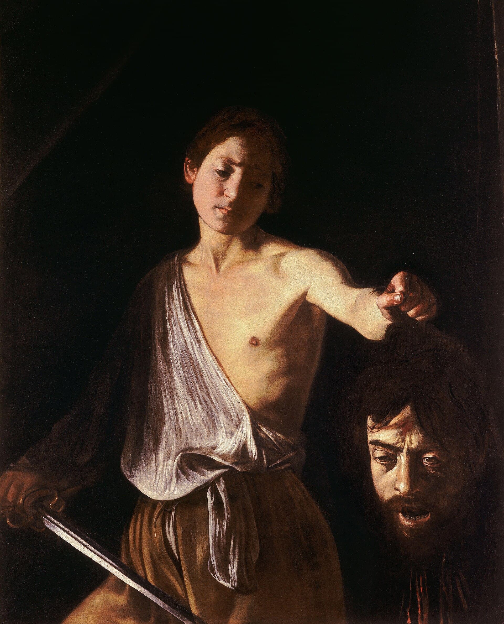 Caravaggio, Dawid z głową Goliata 1610 — z czarnego tła wyłania się młodzieniec w białej koszuli zsuniętej z ramienia; w wyprostowanej ręce trzyma za włosy odciętą brodatą głowę o rozchylonych ustach i przymkniętych oczach, przy dolnej krawędzi błyszczy wąskie ostrze miecza. Światło wydobywa tylko jego twarz, tors i tę głowę, reszta płótna tonie w czerni.