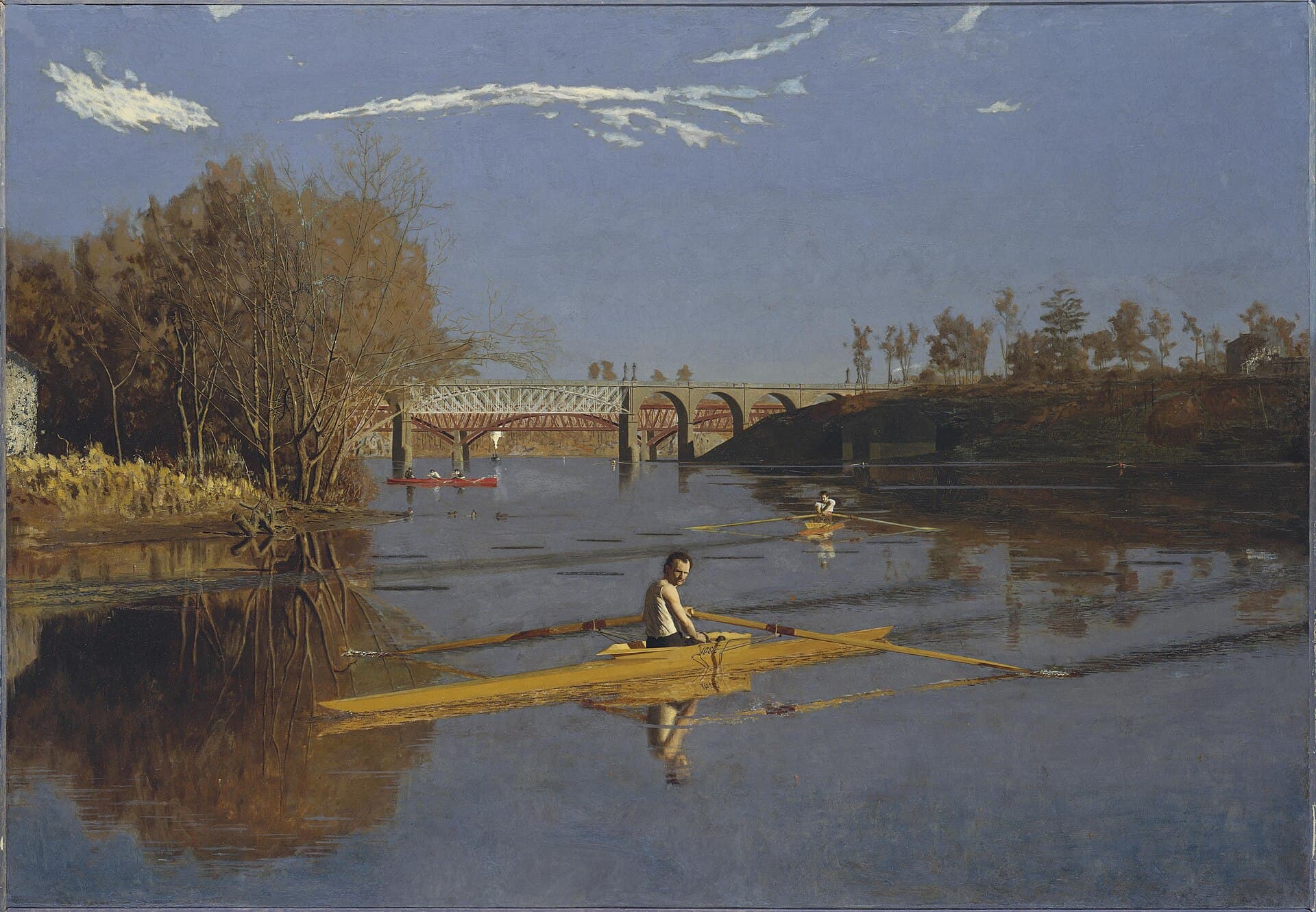Thomas Eakins, Max Schmitt w skifie, 1871, Metropolitan Museum of Art w Nowym Jorku — obraz olejny: wąska łódź wioślarska na spokojnej wodzie, siedzący w niej mężczyzna przestał wiosłować i odwraca głowę w stronę patrzącego, dalej na rzece drugi skif i czerwona łódź z kilkuosobową osadą, w tle kratownicowy most kolejowy i kamienne przęsła, nad brzegiem niskie jesienne światło