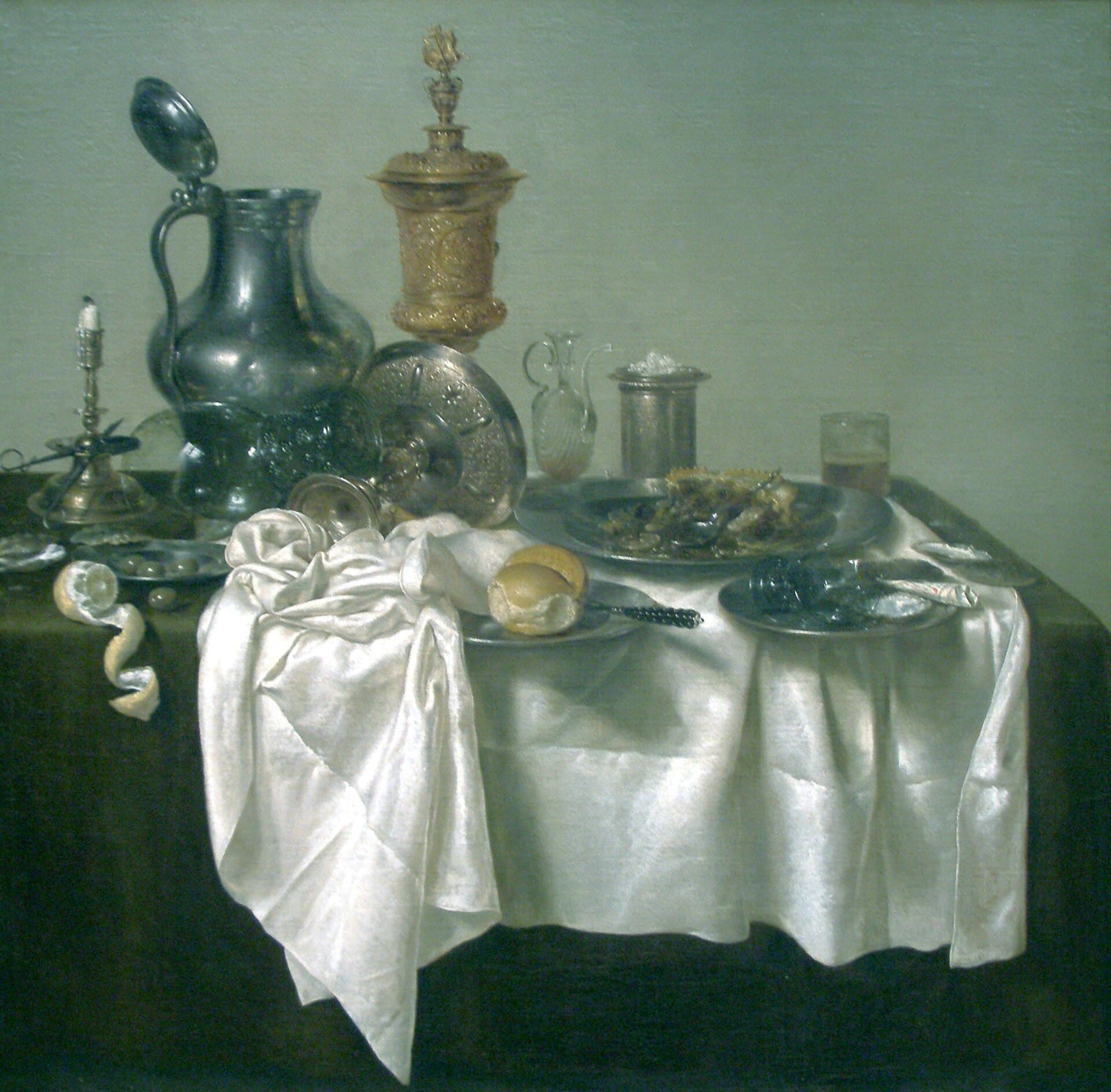 Willem Claesz. Heda, Śniadanie z pasztetem 1635 - martwa natura w chłodnej gamie szarości i srebra, na jasnym, pustym tle bez ściany i bez okna. Na ciemnym stole leży zsunięty w bok biały obrus, a na nim wysoki cynowy dzban z odchylonym wieczkiem, złocony puchar z pokrywą, świecznik ze zgaszoną świecą, nadkrojony pasztet na cynowym półmisku i kielich przewrócony na bok; z lewej krawędzi zwisa spiralnie zdjęta skórka cytryny.