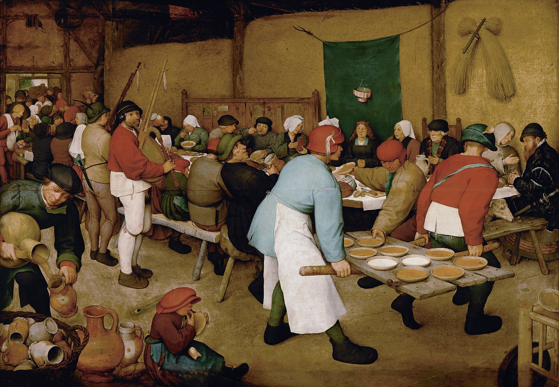 Pieter Bruegel Starszy, Wesele chłopskie 1567, Kunsthistorisches Museum Wiedeń — wnętrze stodoły ze ścianą ze snopów zboża, przy długim stole tłoczą się goście, panna młoda w ciemnej sukni siedzi ze splecionymi dłońmi przed zawieszoną zieloną tkaniną, dwaj mężczyźni niosą przez izbę drzwi zdjęte z futryny i zastawione rzędem misek, na podłodze z przodu siedzi dziecko w za dużej czerwonej czapce z miską w ręku, w lewym rogu kosz glinianych dzbanów