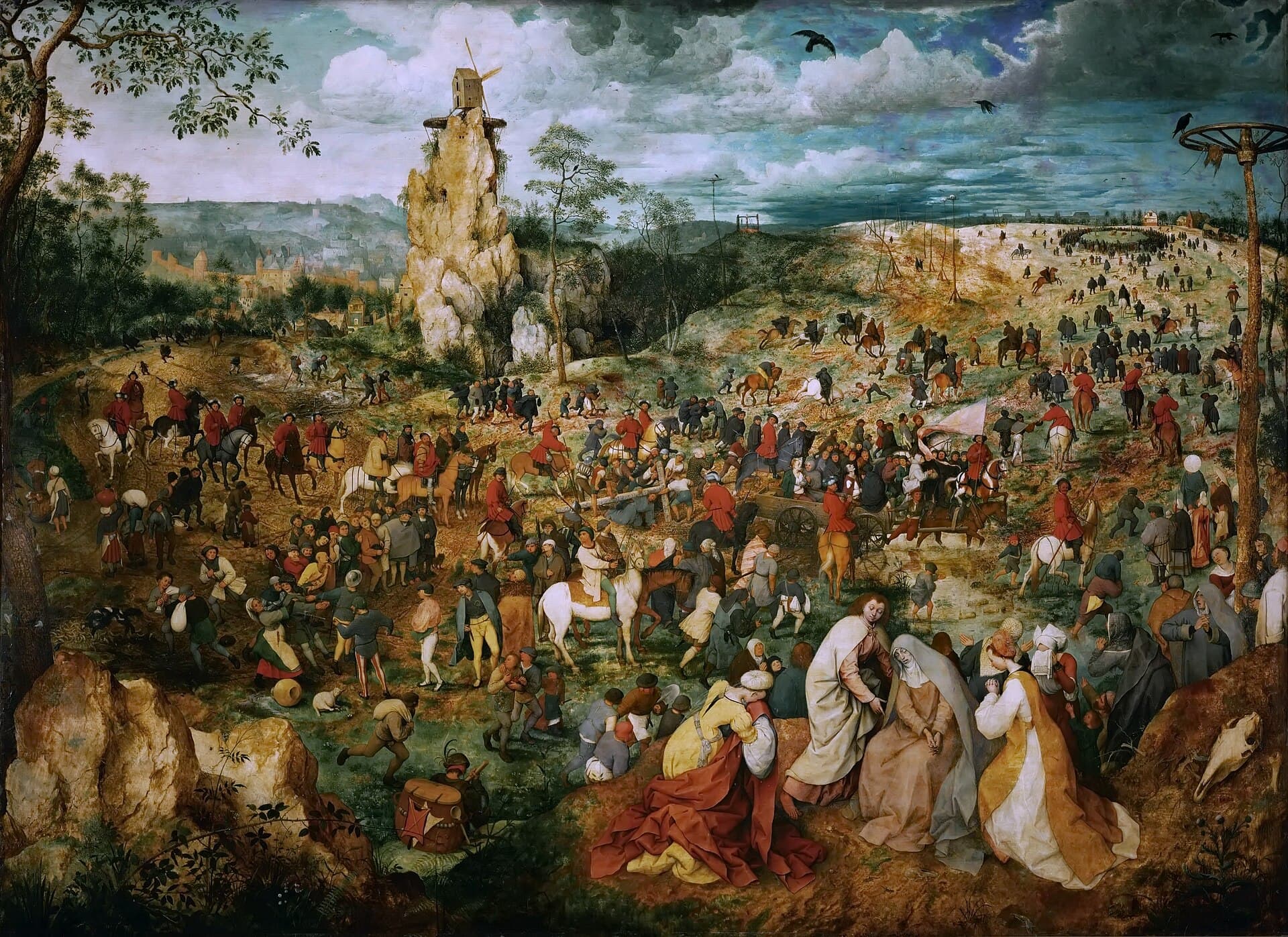 Pieter Bruegel starszy, Droga krzyżowa, 1564 — rozległy pejzaż widziany z góry: pośrodku sterczy biała skała z wiatrakiem na szczycie, w oddali z lewej rysuje się miasto o wieżach, a po prawym zboczu ciągną setki drobnych figurek, część konno, w jaskrawoczerwonych kurtkach. Na szczycie zbocza tłum ustawił się w wielki krąg wokół dwóch pustych krzyży, przy prawej krawędzi sterczy koło na wysokim słupie, a w powietrzu krążą kruki.