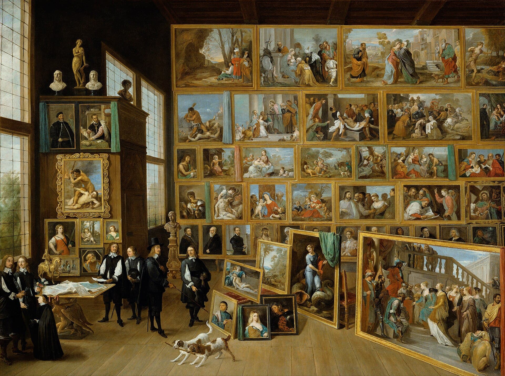 David Teniers Młodszy, Arcyksiążę Leopold Wilhelm w swojej galerii obrazów w Brukseli, około 1651, olej - wnętrze barokowej galerii, w którym ściany od podłogi po sufit są gęsto obwieszone dziesiątkami obrazów w złoconych ramach, zestawionych w jedną kolekcję; po lewej arcyksiążę w czarnym stroju i kapeluszu ogląda zbiory z gośćmi, przy stole leżą ryciny i rysunki, a na pierwszym planie dwa psy
