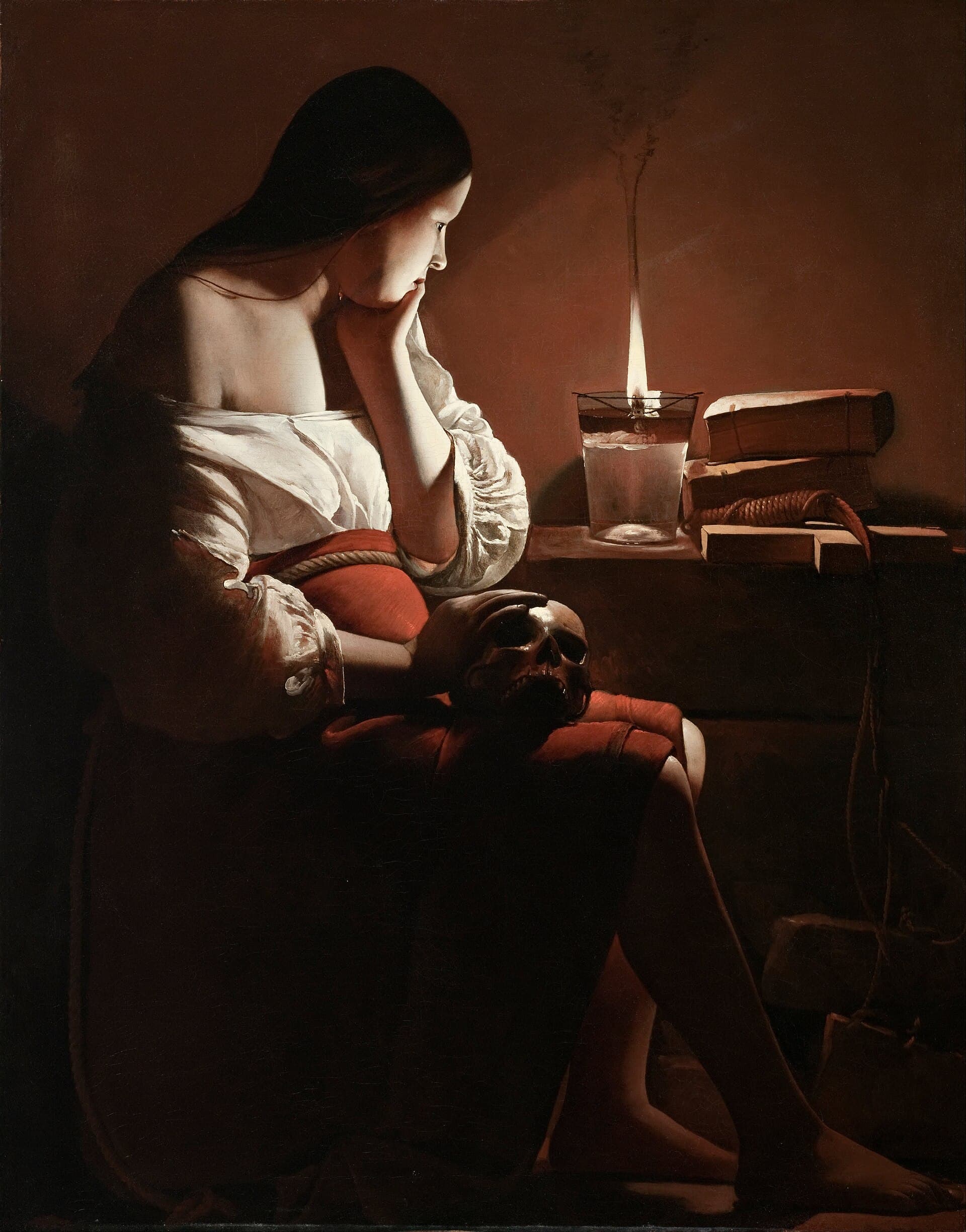 Georges de La Tour, Magdalena z kopcącym płomieniem, ok. 1640, olej - mroczna, kameralna scena w stylu mistrza światłocienia: Maria Magdalena siedzi w ciemnym wnętrzu z dłonią wspartą na ludzkiej czaszce, obok książka, a na stole pali się pojedynczy, lekko dymiący płomień; całą kompozycję organizuje to jedno źródło światła wyłaniające postać z mroku