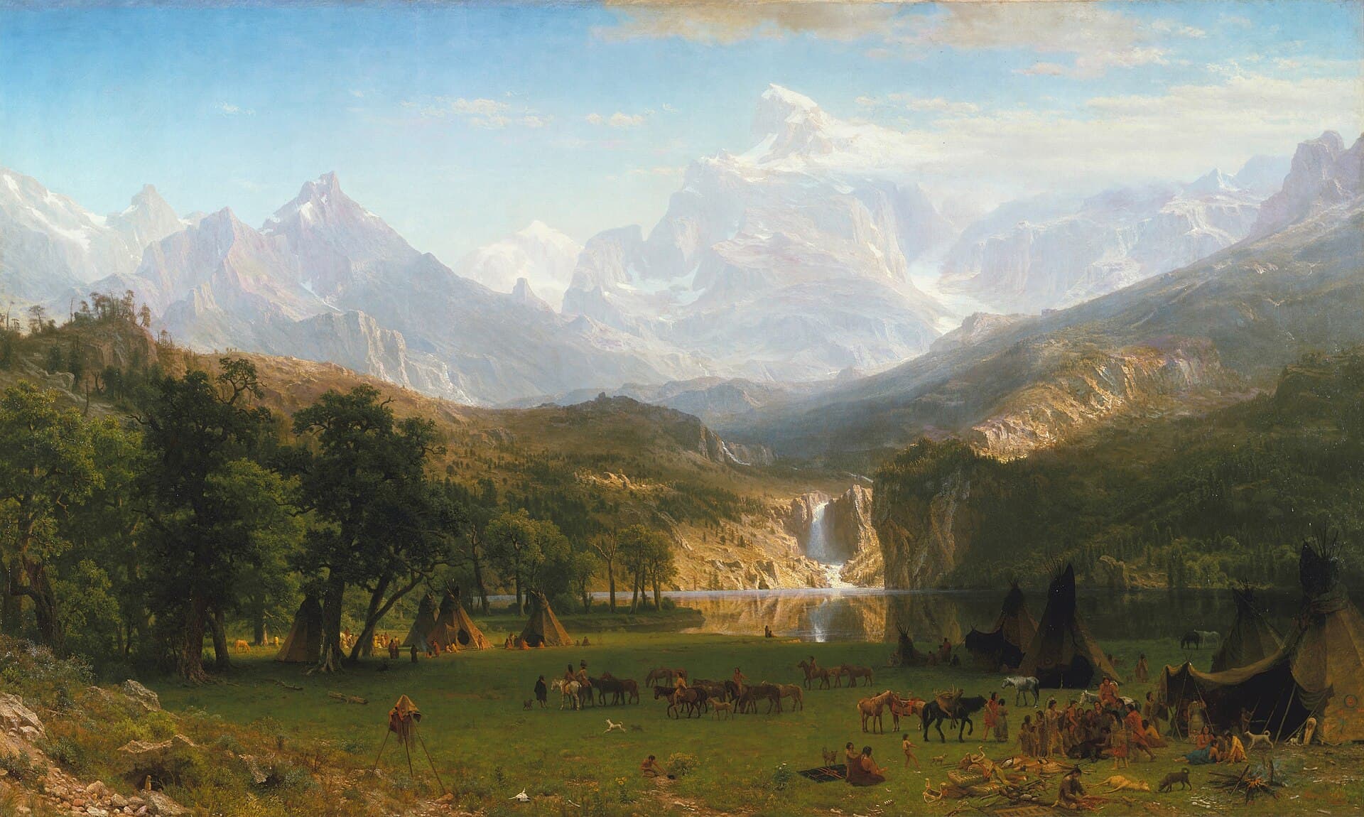Albert Bierstadt, Góry Skaliste - Szczyt Landera, 1863, olej na płótnie - rozległy, romantyczny pejzaż: pośrodku strzelisty, ostro zakończony granitowy szczyt skąpany w świetle przebijającym przez chmury, zbocza opadają ku zielonej dolinie z jeziorem i wodospadem, a na pierwszym planie, u podnóża gór, obozowisko rdzennych mieszkańców z końmi i namiotami