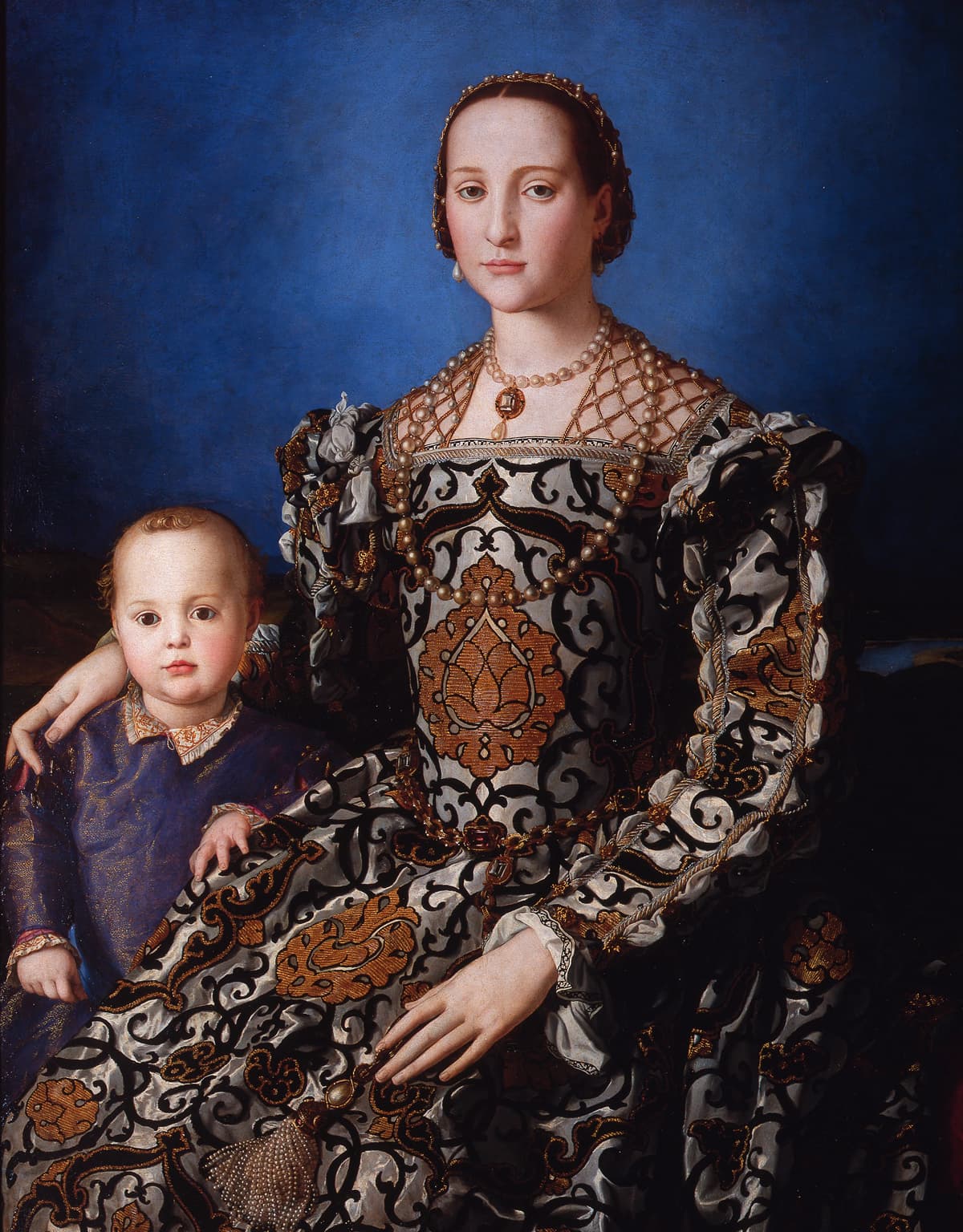 Agnolo Bronzino, Portret Eleonory di Toledo z synem Giovannim ok. 1545 - kobieta o bardzo bladej, nieruchomej twarzy siedzi frontalnie na tle głębokiego błękitu. Suknia z białego jedwabiu w czarne i złote arabeski, o sztywnym staniku i bufiastych rękawach, zajmuje niemal całą dolną połowę obrazu; perły oplatają siatką jej włosy, dwoma sznurami szyję i spływają po staniku, a dłoń spoczywa na ramieniu kilkuletniego jasnowłosego chłopca stojącego po lewej stronie obrazu.