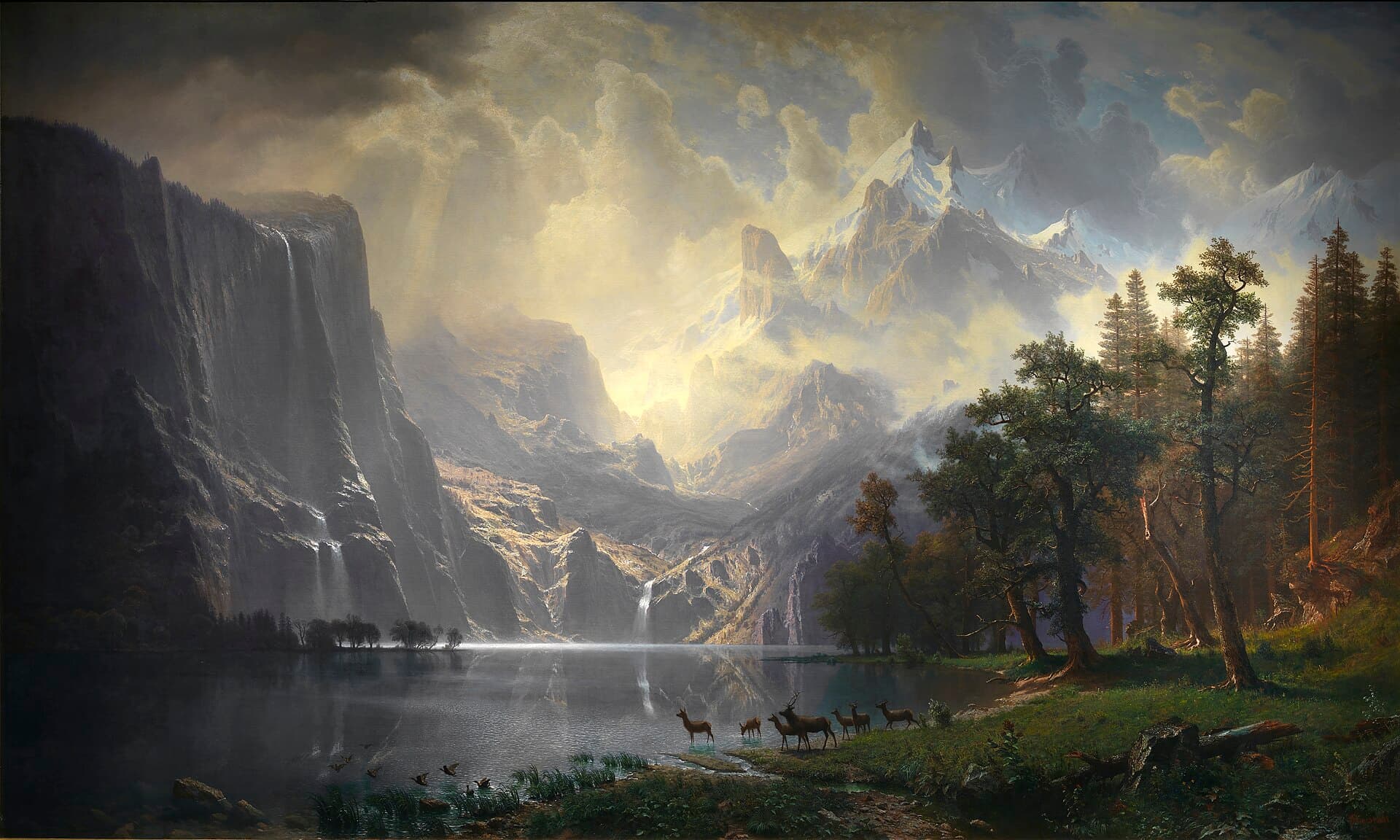 Albert Bierstadt, Among the Sierra Nevada Mountains, California, 1868 — szeroka górska dolina: na pierwszym planie gładka tafla jeziora, przy brzegu z prawej stoi kilka jeleni, nad wodą zrywają się ptaki. W głębi ze skalnej ściany po lewej spadają wąskie wodospady, dalej piętrzą się ośnieżone szczyty, a górną połowę płótna wypełnia rozświetlone niebo z kłębami chmur.