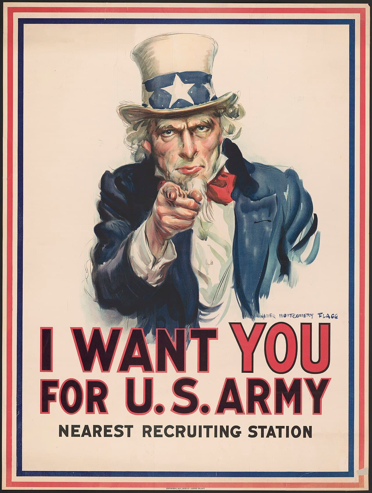 James Montgomery Flagg, plakat werbunkowy I Want You for U.S. Army, 1917 — popiersie siwego mężczyzny z bródką, w wysokim białym cylindrze z granatową opaską i białą gwiazdą, w granatowym surducie i czerwonej muszce, na kremowym tle w czerwono-granatowej ramce. Zmarszczony patrzy wprost przed siebie, a wyciągnięta ku widzowi dłoń jest tak skrócona perspektywicznie, że sam wskazujący palec wypełnia środek plakatu; niżej wielkie czerwono-granatowe litery I WANT YOU FOR U.S. ARMY.