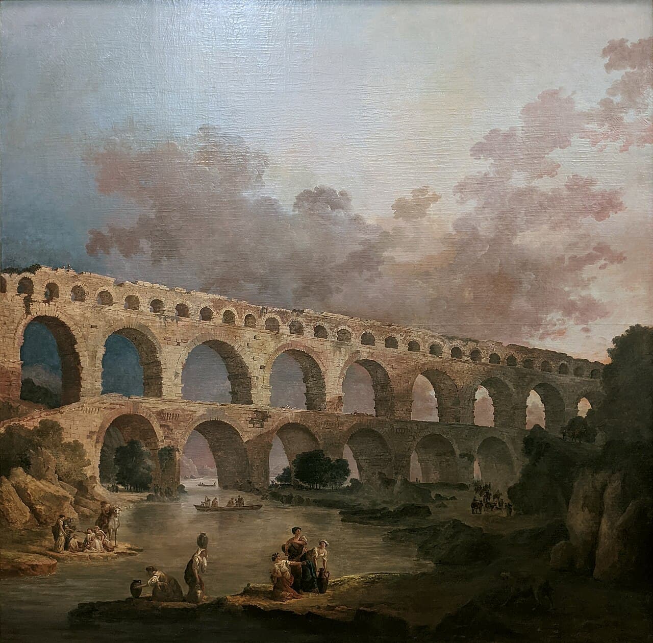 Hubert Robert, Le Pont du Gard (1787) — potężny, trzypiętrowy rzymski akwedukt z kamiennych arkad przerzucony nieprzerwaną linią przez szeroką dolinę rzeki; u jego podnóża maleńkie ludzkie postacie oddają ogrom infrastruktury wzniesionej, by pokonać odległość