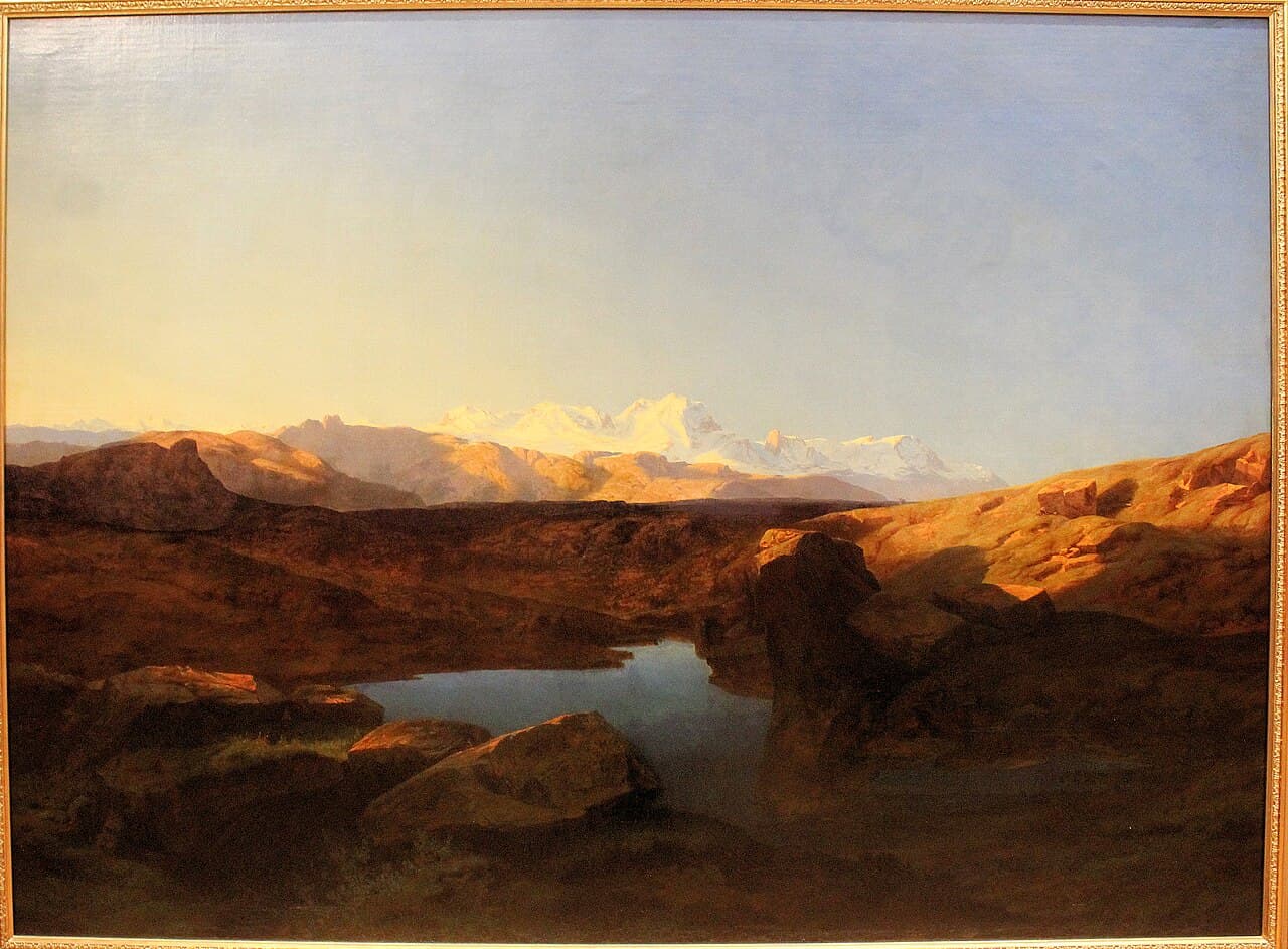 Alexandre Calame, Łańcuch Monte Rosa o wschodzie słońca, XIX wiek, olej - ciemne, brunatne pogórze zajmuje dolne dwie trzecie obrazu, w zagłębieniu między głazami leży małe jezioro, dalej pasmo pogrążone w cieniu, a na horyzoncie ośnieżone szczyty Monte Rosa rozświetlone porannym słońcem pod bladym niebem