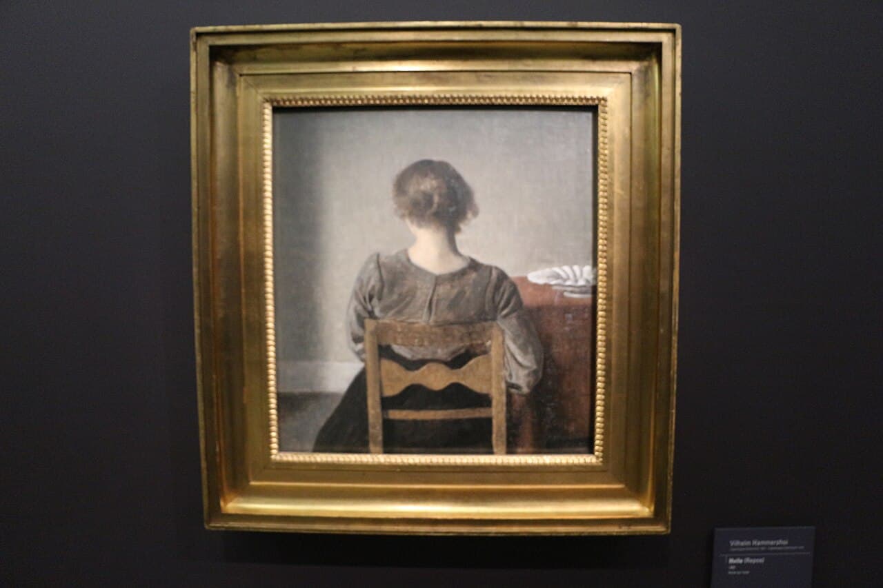 Vilhelm Hammershøi, Odpoczynek (Hvile, 1905) - kobieta siedząca tyłem, z odsłoniętym karkiem, twarz ukryta przed widzem
